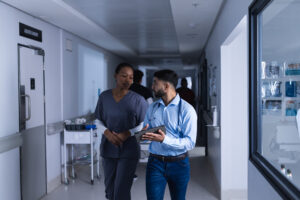 Diverse Male And Female Doctors Talking And Using Tablet Walking In Hospital Corridor. Medicine, Healthcare, Communication And Medical Services, Unaltered. - Contabilidade em São Jose dos Campos | Souza & Souza